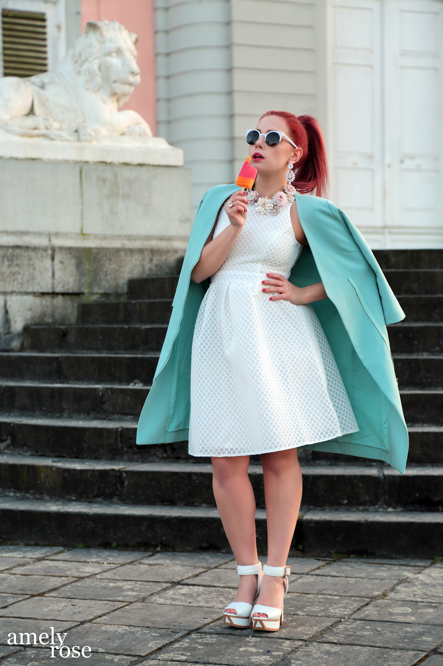 amely rose in einem sommeroutfit mit einem blauen mantel