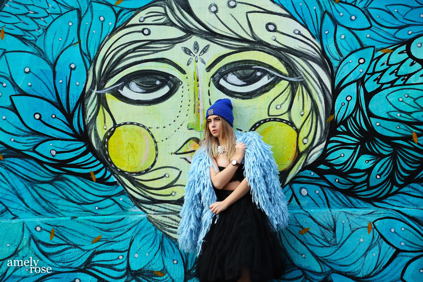 amely rose vor einem tollen blauen graffiti in köln ehrenfeld.wer streetart mag und fashion wird diesen post lieben. all black everything und eine tolle fake fur jacke. ein coat mit blauen franzeln.