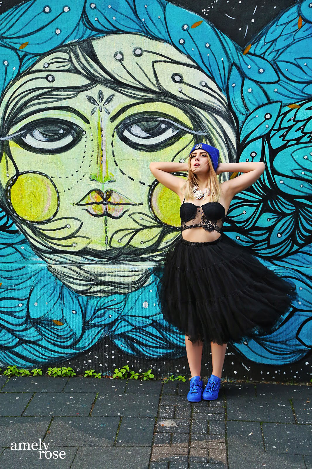 amely rose vor einem tollen blauen graffiti in köln ehrenfeld.wer streetart mag und fashion wird diesen post lieben. all black everything und eine tolle fake fur jacke. ein coat mit blauen franzeln.