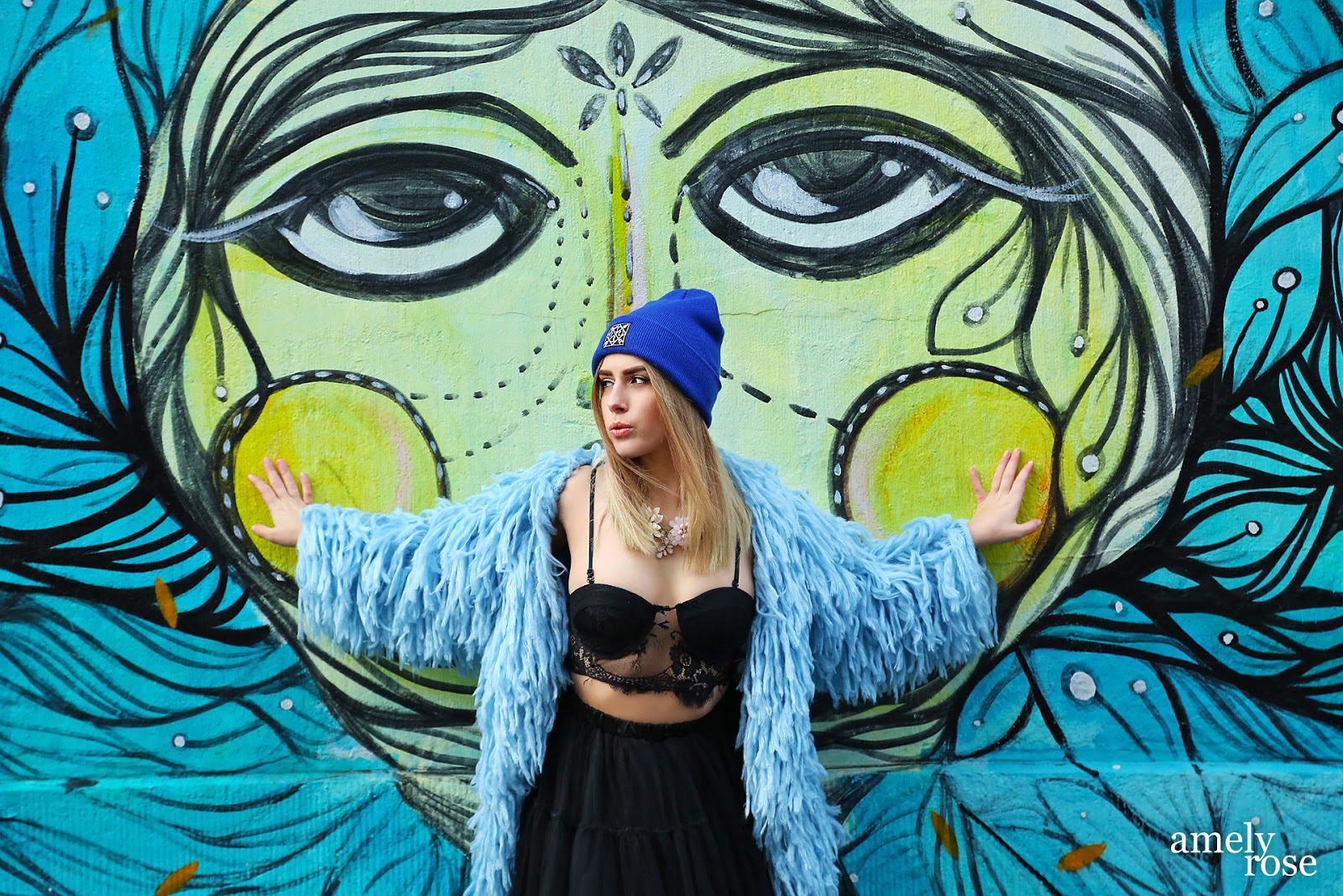 amely rose vor einem tollen blauen graffiti in köln ehrenfeld.wer streetart mag und fashion wird diesen post lieben. all black everything und eine tolle fake fur jacke. ein coat mit blauen franzeln.