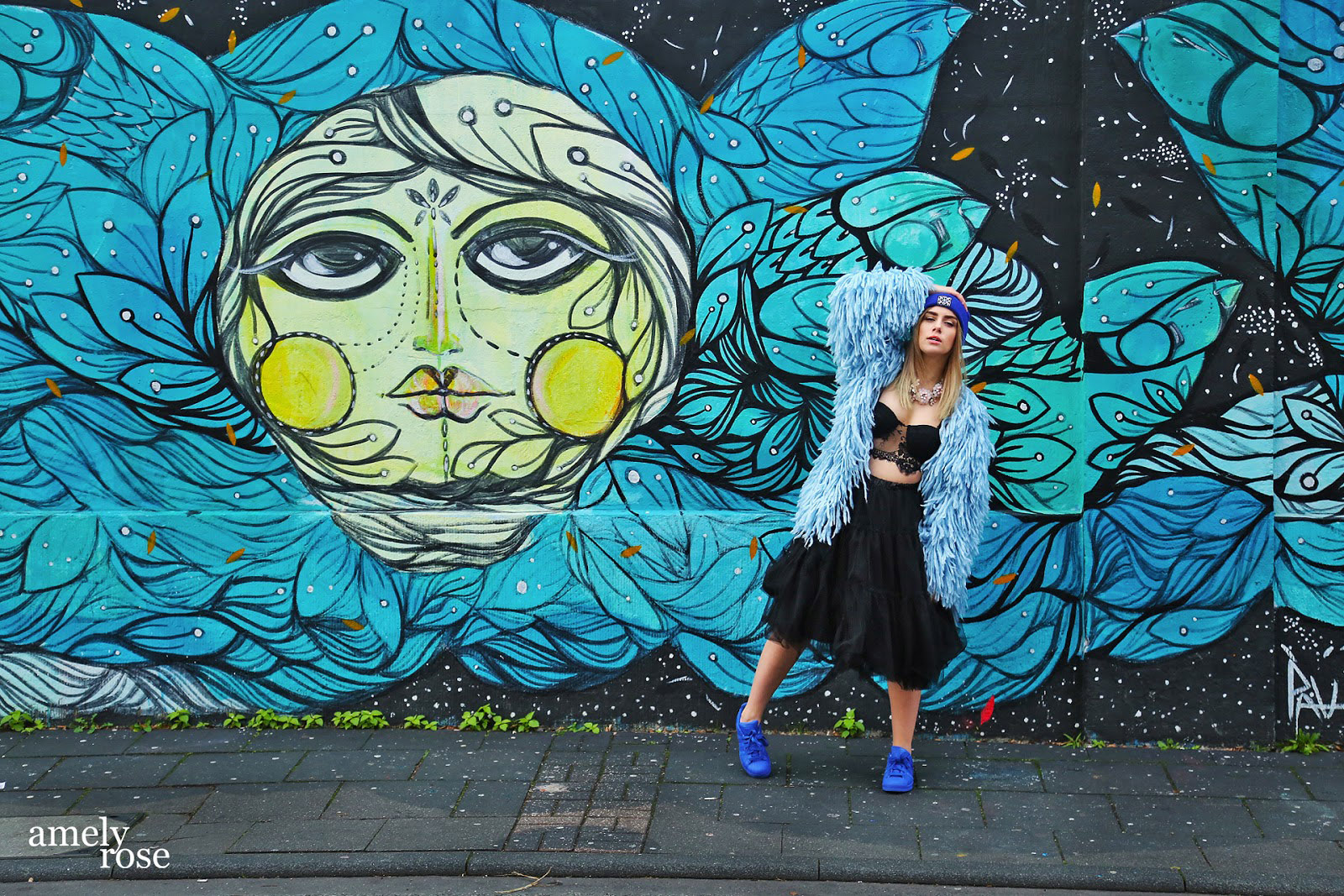 amely rose vor einem tollen blauen graffiti in köln ehrenfeld.wer streetart mag und fashion wird diesen post lieben. all black everything und eine tolle fake fur jacke. ein coat mit blauen franzeln.