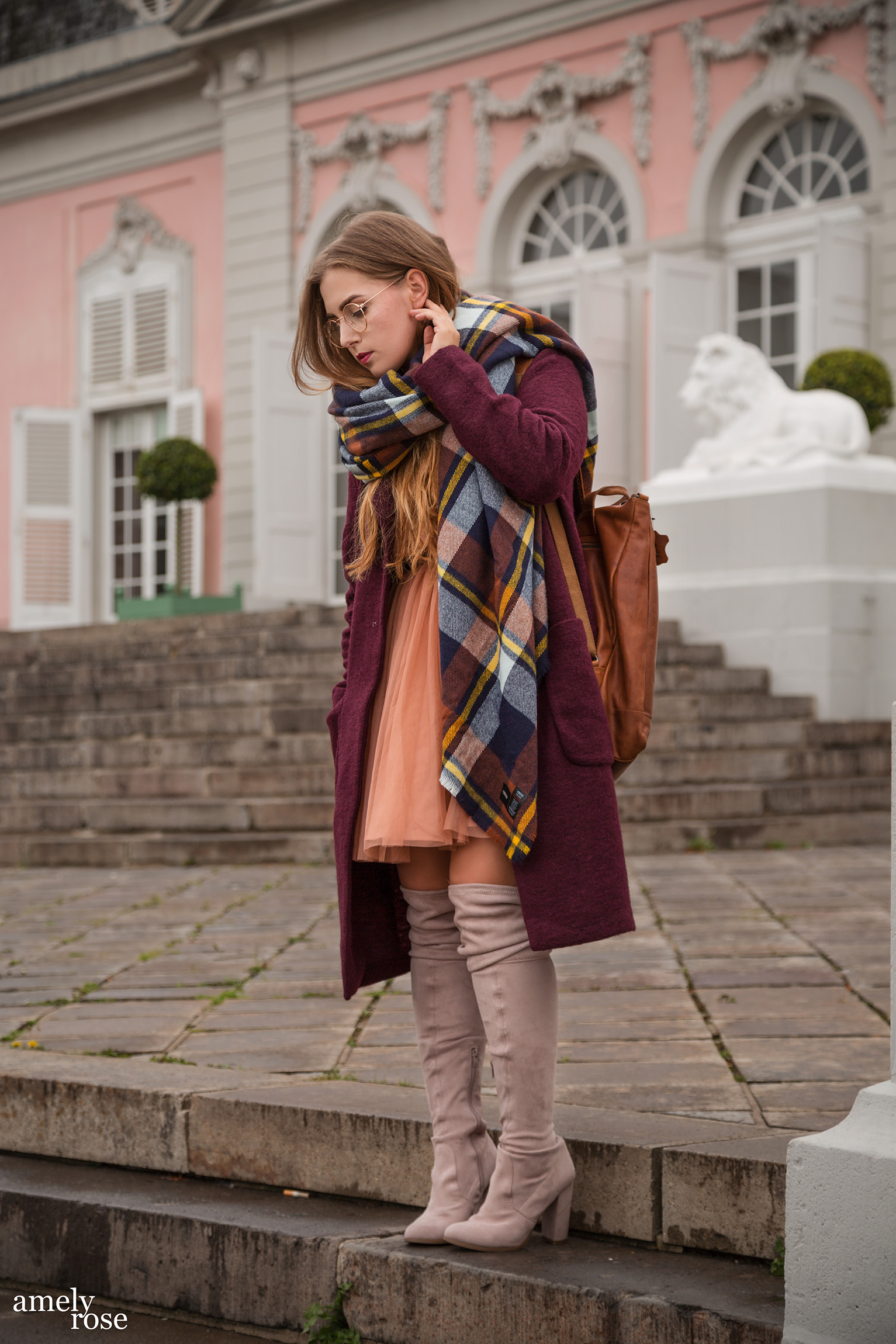 Amely Rose zählt zu den erfolgreisten deutschen fashionblogger. Sie zeigt einen herbstlook mit erdigentönen einem wollmantel von H&M, sowie einem Zara Kleid, Overkneeboots und einem oversize Schal. Dazu ein schöner lederrucksack kombiniert.