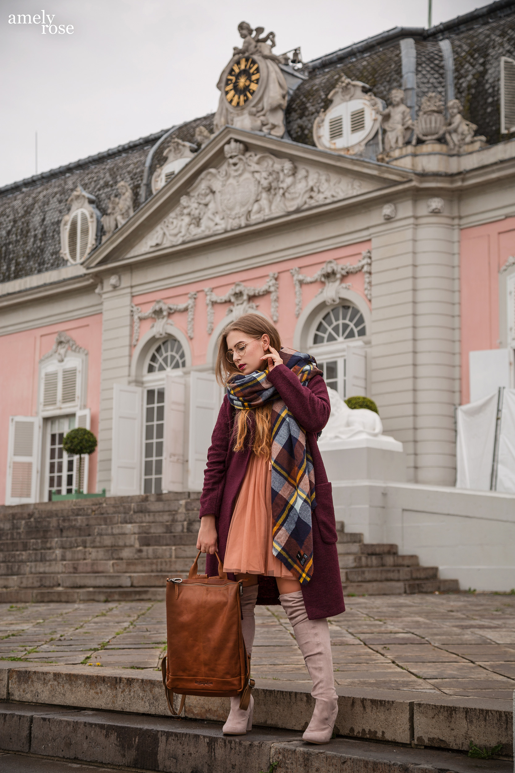 Amely Rose zählt zu den erfolgreisten deutschen fashionblogger. Sie zeigt einen herbstlook mit erdigentönen einem wollmantel von H&M, sowie einem Zara Kleid, Overkneeboots und einem oversize Schal. Dazu ein schöner lederrucksack kombiniert.