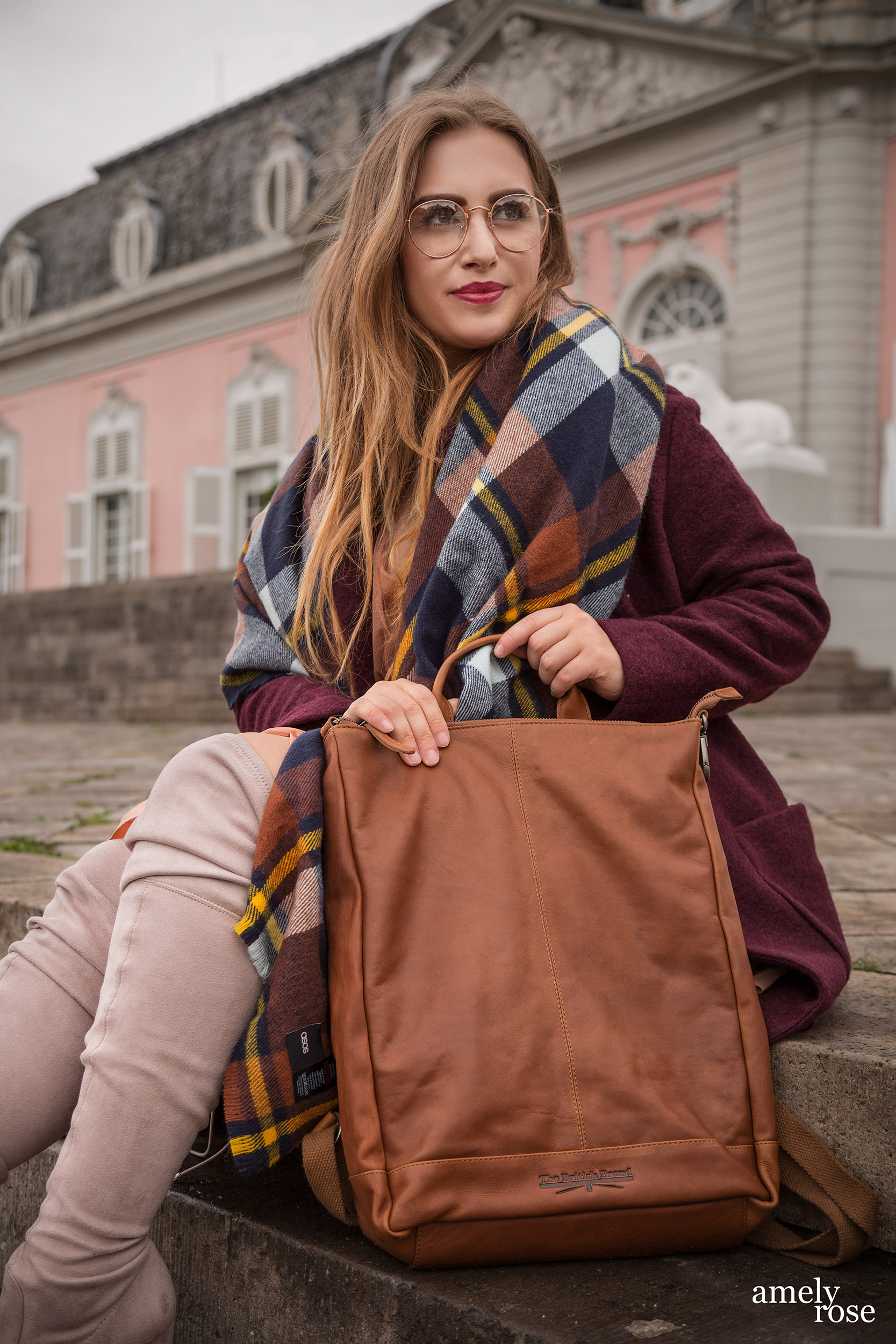 Amely Rose zählt zu den erfolgreisten deutschen fashionblogger. Sie zeigt einen herbstlook mit erdigentönen einem wollmantel von H&M, sowie einem Zara Kleid, Overkneeboots und einem oversize Schal. Dazu ein schöner lederrucksack kombiniert.