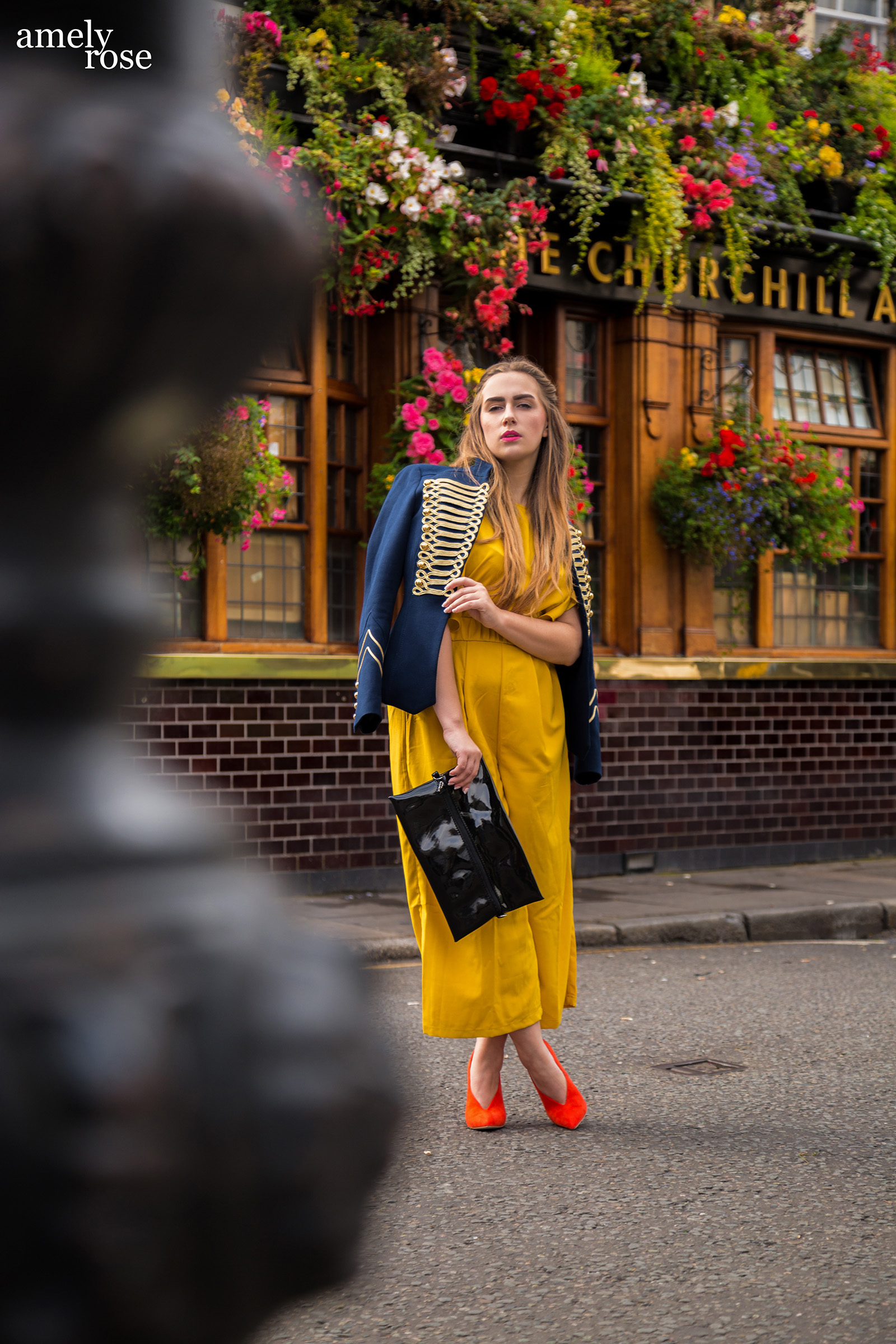 Amely Rose zur Fashionweek in London vor demlondoner Hotspot Pub Churchill arms im gelben Enteiler, Zara Jacke und orangen Pumps.