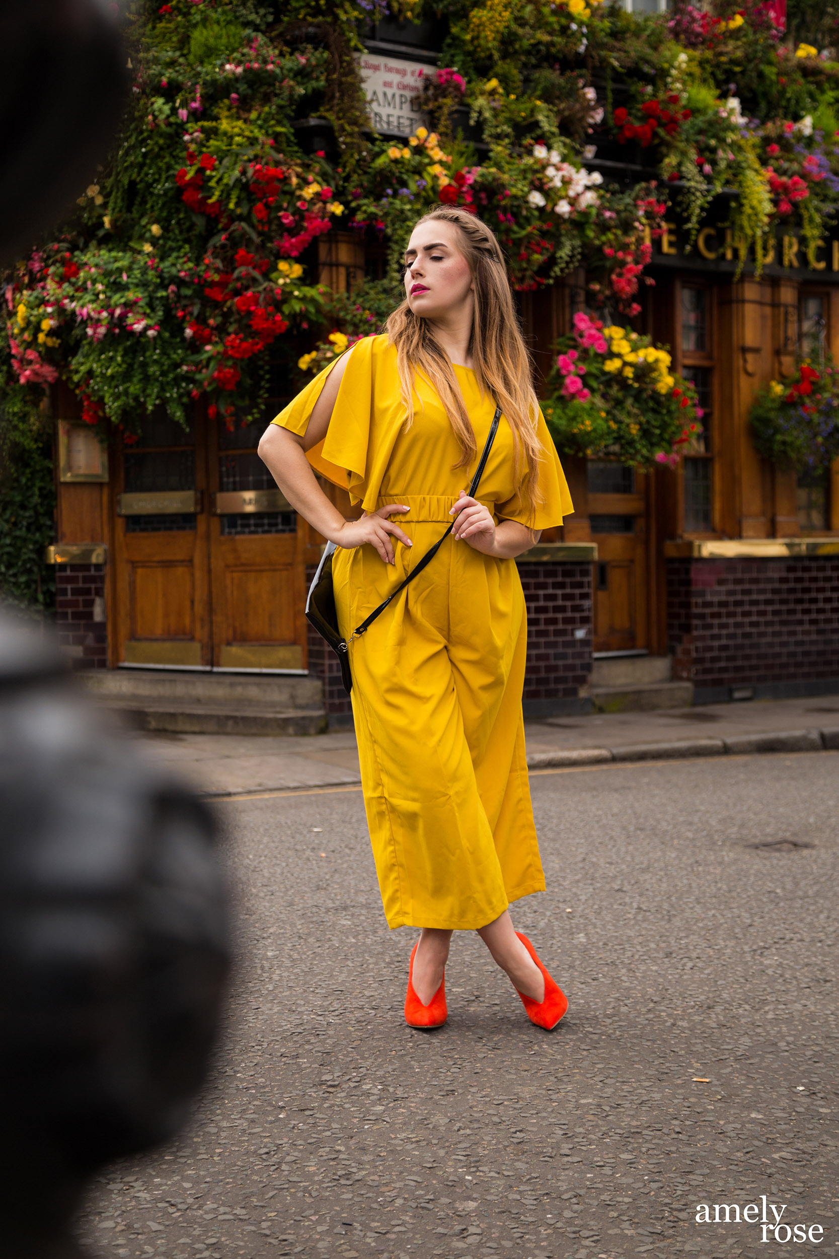 amely rose,german fashionblogger in einem gelben einteiler und einem sommerlook, zeigt ihr ootd zur lfw der londoner fashion week vor dem szeneviertel und pup churchillarms.